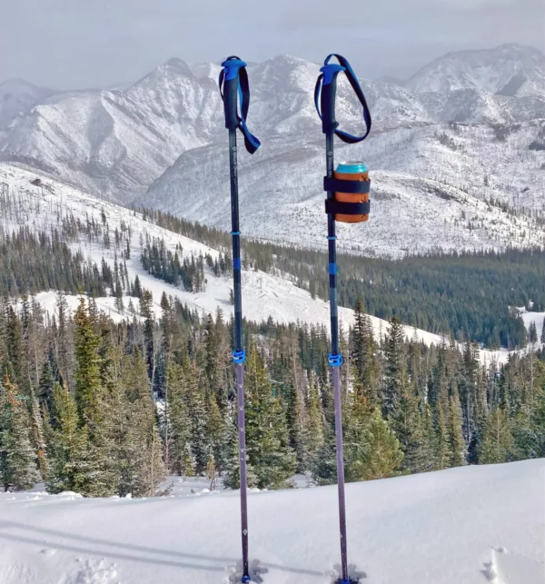 Ski poles with a beer attached mountain valley background